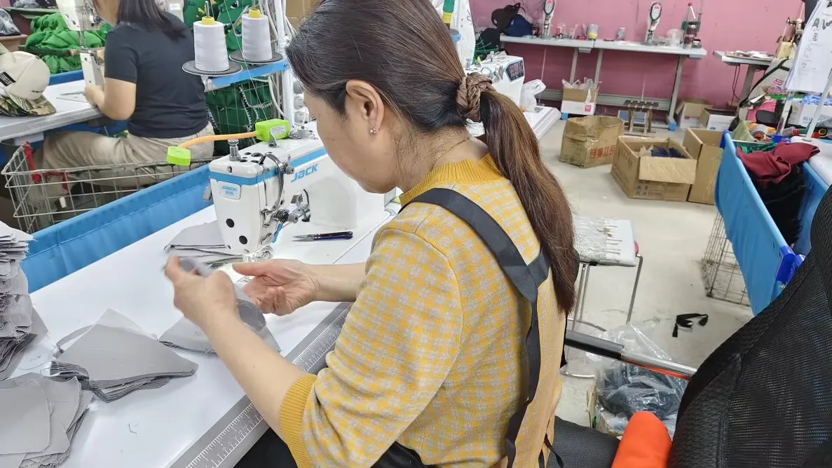 Jiesa sewing operator at a cap workstation